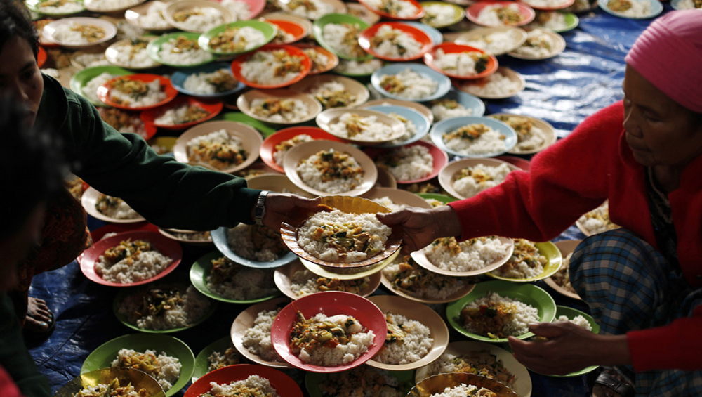 A volunteer prepares breakfast for villagers at a camp in the district of Tanah Karo