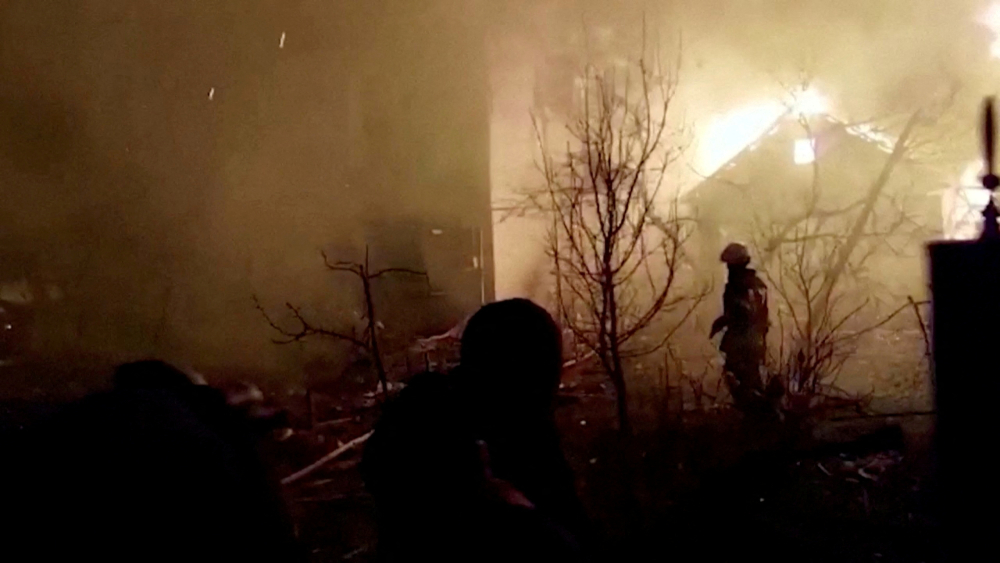 Bomberos caminan sobre los escombros mientras un edificio se quema luego de un ataque ruso durante la invasión de Ucrania, en la ciudad de Zhytomyr. Foto: Reuters