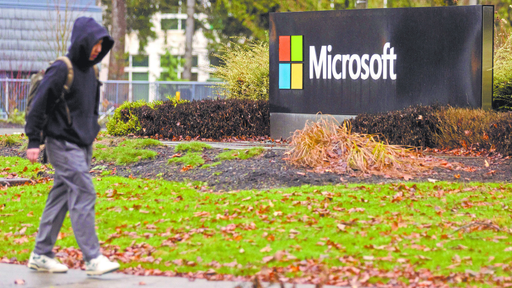 A person walks past Microsoft signage at the headquarters in Redmond