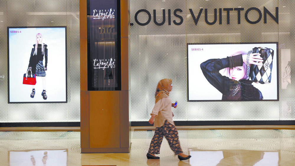 File photo of an Indonesian woman walking past a Louis Vuitton shop at a mall in Jakarta