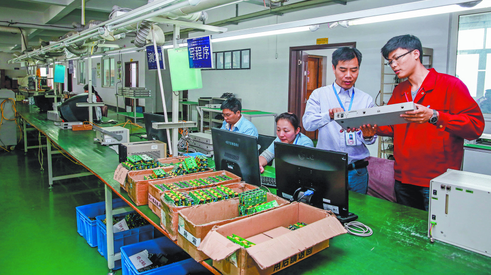 JIANGXI CHINA-May 13, 2014: Jiangxi Shanshui Photoelectric Co., Ltd. research factory workshop, information engineers are developing computer chips, electronic workers put chips on the circuit board.