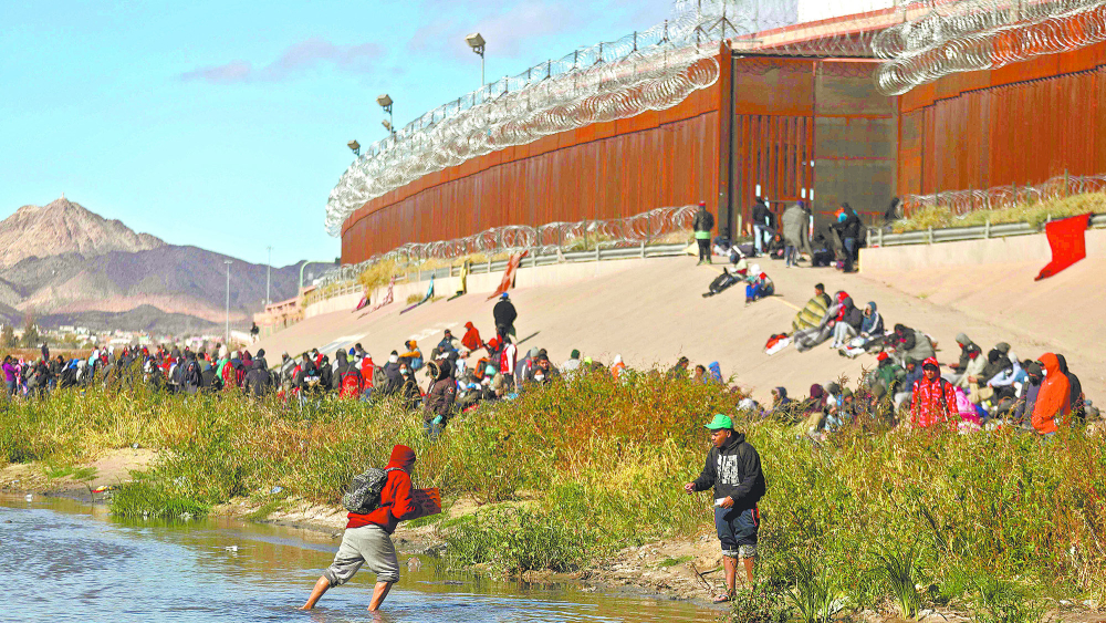 En imagen del 13 de diciembre, migrantes cruzan el río Bravo para entregarse a los agentes de la Patrulla Fronteriza de EU en El Paso, Texas. Foto: AFP