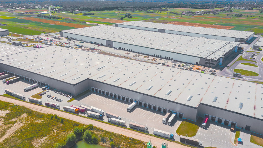 Aerial Shot of Industrial Warehouse Loading Dock where Many Truck with Semi Trailers Load Merchandise.