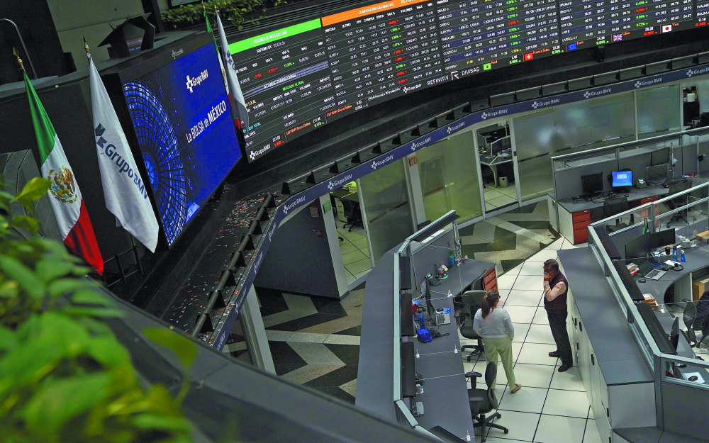 Employees interact as a ticker displays stock exchange data at Mexico's stock exchange, in Mexico City, Mexico June 1, 2021. REUTERS/Toya Sardo Jordan