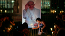 La gente coloca velas encendidas cerca de una imagen del Papa Francisco durante una vigilia para orar por su salud en Buenos Aires el 7 de marzo de 2025.
