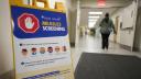 Una persona pasa junto a un cartel de detección de sarampión cerca de la entrada del Hospital Victoria en London, Ontario.