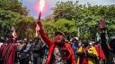 Un manifestante sostiene una bengala durante una protesta tras la muerte de un mototaxista.