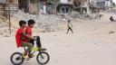 Children ride a bicycle across a war-devastated street in Gaza City on October 2, 2024, amid the ongoing war between Israel and the Palestinian Hamas militant group. (Photo by Omar AL-QATTAA / AFP)