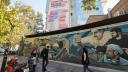 Pedestrians walk past a mural with another one in the background covering the facade of a building in Tehran's Palestine Square, displaying slogans on a map pointing at Israeli cities that read in Hebrew: 'All targets are within reach, we choose' (top) and in Farsi: 'All the targets are available, we will choose' on December 4, 2024. - Tensions between Iran and Israel have increased since the October 7, 2023 attack by Hamas on southern Israel and later Israel's bloody offensive on Gaza and Lebanon where the Islamic republic backs the militant groups Hamas and Hezbolah. (Photo by ATTA KENARE / AFP)