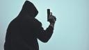 Silhouette of a man wearing a black hoodie and a face mask holding a gun in various poses. Knives concept. Sniper killer. Scary. Dangerous gang.