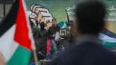 Combatientes palestinos de Hamas escoltan al rehén israelí Or Levy fuera de un escenario antes de entregarlo a un equipo de la Cruz Roja.