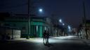 La gente camina por una calle parcialmente iluminada durante un colapso de la red eléctrica nacional, en La Habana, Cuba.