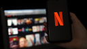 Netflix logo móvil y plataforma en pantalla.