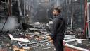 Un hombre observa a un bombero ucraniano terminando de apagar un incendio en el mercado de Barabashovo tras un ataque con drones en Járkov.