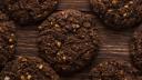 top view of chocolate chip cookies with cereals nuts and cocoa on wooden background
