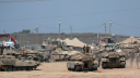 Vehículos militares en el lado israelí de la frontera con Gaza, vistos desde Israel, el 12 de agosto de 2025.