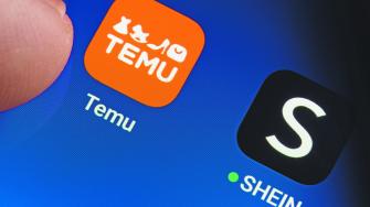 TEMU and SHEIN apps seen on the screen of smartphone and finger pointing at one of them. Temu app and Shein app are chinese budget shopping platforms. Stafford, United Kindom, May 2, 2023