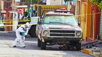 A forensic technician approaches a crime scene where several people died when armed assailants attacked a group of people gathered in the street, in Cuernavaca, Mexico November 20, 2023. REUTERS/Margarito Perez Retana