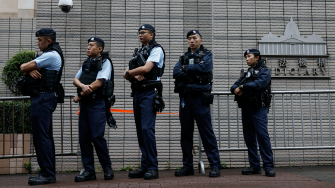 La policía hace guardia frente al edificio de los Tribunales de Magistrados de West Kowloon, antes de la sentencia contra los 45 activistas prodemocracia condenados acusados ​​en virtud de la ley de seguridad nacional, en Hong Kong.