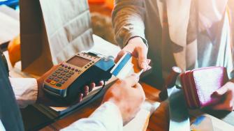 Retail, credit card payment service. Customer paying for order of cheese in grocery shop.