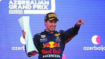 FILE PHOTO: Formula One F1 - Azerbaijan Grand Prix - Baku City Circuit, Baku, Azerbaijan - June 6, 2021 Red Bull's Sergio Perez celebrates with a trophy on the podium after winning the race Pool via REUTERS/Maxim Shemetov/File photoNO RESALES. NO ARCHIVES