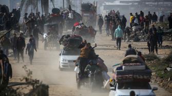 Palestinos desplazados caminan hacia la ciudad de Gaza mientras cruzan el corredor Netzarim desde el sur de la Franja de Gaza.