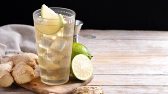Fresh ginger ale drink in tall glass on wooden table