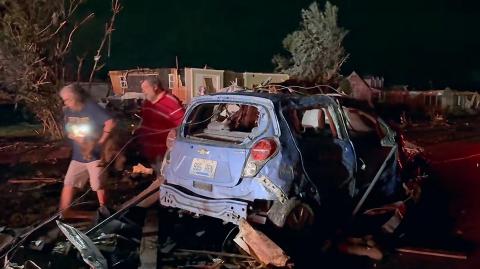 Residentes locales buscan entre los daños causados ​​por el tornado.