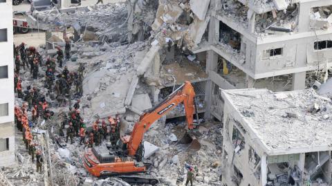 Rescatistas israelíes buscan entre los escombros en el lugar de un ataque con misiles iraníes durante la noche en Bat Yam el 15 de junio de 2025.