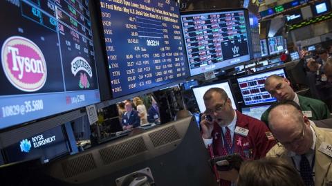 Traders gather at the post that trades Tyson Foods on the floor of the New York Stock Exchange