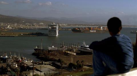 A boy looks out at the port where a cruise ship is docked in Ensenada, Mexico, Tuesday Nov. 9, 2010.  Mexican seagoing tugboats are expected to reach disabled cruise ship Carnival Splendor, carrying 4,500 passengers, on Tuesday afternoon to begin the process of towing it to the Mexican port of Ensenada. The ship left from Long Beach on Sunday and was 200 miles (320 kilometers) south of San Diego when an engine room fire cut its power early Monday, according to the Miami-based Carnival Cruise Lines. (AP Photo/Guillermo Arias)