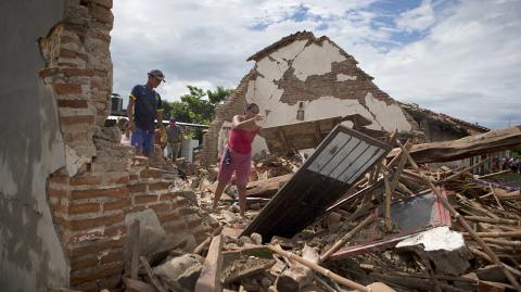 A woman removes debris from the remains of her home, which was destroyed in Thursday's magnitude 8.1 earthquake, in Union Hidalgo, Oaxaca state, Mexico, Sunday, Sept. 10, 2017. Mexico's government is distributing food to jittery survivors of an earthquake while residents have continued to sleep outside, fearful of more collapses and aftershocks. (AP Photo/Rebecca Blackwell)