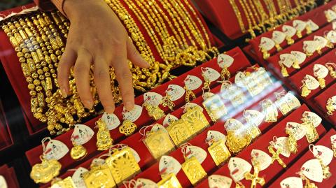 JOYERIA - A Chinese gold shop assistant shows off various gold jewellery at a shop in Hefei, east China