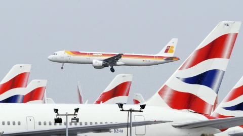 File photo of Iberia Airlines passenger jet passing over British Airways aircraft as it lands at Heathrow Airport