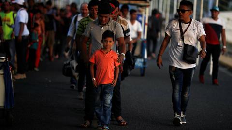 People belonging to a caravan of migrants from Honduras en route to the United States, wait to be processed by Mexican immigration officers on the border bridge in Hidalgo - People belonging to a caravan of migrants from Honduras en route to the United States, wait to be processed by Mexican immigration officers on the border bridge in Hidalgo, Mexico, January 19, 2019. REUTERS/Jose Cabezas