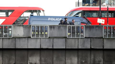 Police officers and emergency staff work at the site of an incident at London Bridge