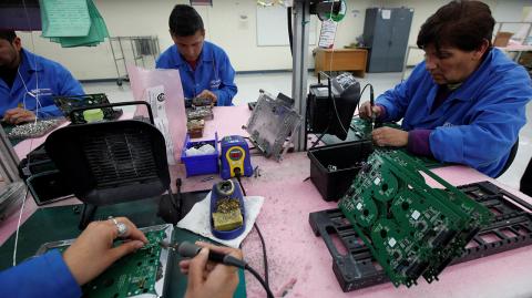 Employees weld printed circuit boards at the assembly line of a factory that exports to the U.S. in Ciudad Juarez