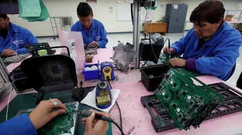 FILE PHOTO: Employees weld printed circuit boards at the assembly line of a factory that exports to the U.S. in Ciudad Juarez