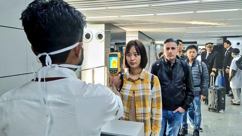 In this handout photograph taken and released by the Ministry of Civil Aviation (MoCA) on January 21, 2020, a man (L) uses a thermographic camera to screen the head of people at Netaji Subhash Chandra Bose International Airport in Kolkata, following the Ministry of Health and Family Welfare's advisory to screen passengers arriving in India from China and Hong Kong regarding the novel coronavirus (nCoV) issue. - Asian countries on January 21 ramped up measures to block the spread of a new virus as the death toll in China rose to six and the number of cases jumped to almost 300, raising concerns in the middle of a major holiday travel rush. (Photo by Handout / Ministry of Civil Aviation (MoCA) / AFP) / RESTRICTED TO EDITORIAL USE - MANDATORY CREDIT 