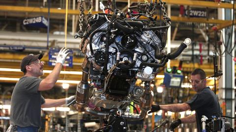 (FILES) In this file photo taken on September 16, 2013, workers install a Ford EcoBoost engine into a 2014 F150 truck chassis on the assembly line at Ford's Dearborn Truck Plant  in Dearborn, Michigan. - Detroit's three automakers have agreed to UAW demands to temporarily shut down all North America plants as a precaution against coronavirus, on March 18, 2020 (Photo by BILL PUGLIANO / GETTY IMAGES NORTH AMERICA / AFP)