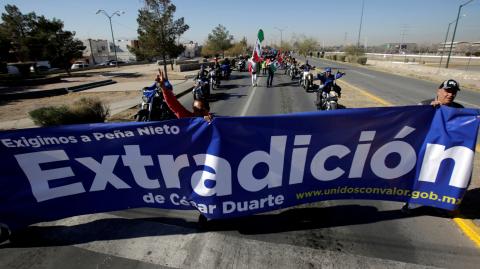 Personas sostienen una pancarta  para exigir al gobierno extradición del ex gobernador César Duarte, acusado de corrupción. Foto: Reuters