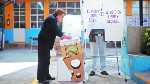 A woman casts her ballot during the election of 60 deputies, to form the Constituent Assembly that will create a constitution for Mexico City, in Mexico City