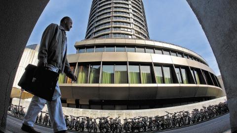 A man walks past the headquarters of the Bank for International Settlements (BIS) in Basel