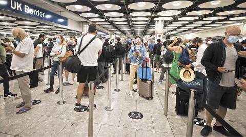 FILE PHOTO: Arriving passengers queue at UK Border Control at the Terminal 5 at Heathrow Airport in London