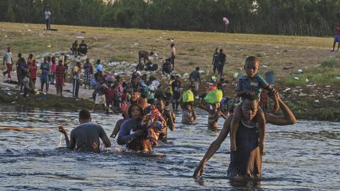 Haitian migrants continue to cross across the US-Mexico border on the Rio Grande as seen from Ciudad Acuna, Coahuila state, Mexico on September 20, 2021. - Migrant families sent back to Haiti by the United States after attempting to enter the country from Mexico are angry at their treatment and fearful of returning back home to a life punctuated by gang violence. The deportation of Haitian migrants had been temporarily suspended by Washington after a devastating earthquake hit the Caribbean nation last month.But in recent days, more than 15,000 Haitians crossed into the country from Mexico and found themselves stranded for days in Texas under a bridge spanning the Rio Grande river, blocked from moving onwards. (Photo by PAUL RATJE / AFP)