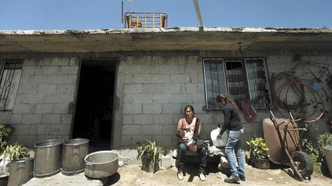 Rosa Zuniga, 38, breastfeeds her son while her daughter cleans a pot outside her house in Zitlaltepec, July 26, 2013. Picture taken July 26, 2013. Mexico's poverty rate fell 0.6 percent between 2010 and 2012 to 53.3 million people, the government's social development agency Coneval said. Factoring in population growth, the ranks of the poor grew by half a million people in that time. REUTERS/Edgard Garrido (MEXICO - Tags: SOCIETY POVERTY)