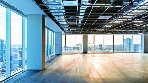 Vacant office space offering views of the city. Open ceiling showing ventilation system. Shot just after construction was completed on a late winter afternoon in downtown Montreal, Quebec, Canada.