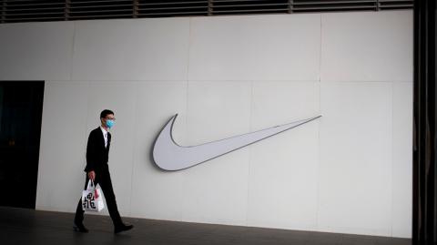 A man wearing a face mask passes a Nike store, as the country is hit by the novel coronavirus outbreak, in Beijing, China, March 2, 2020. REUTERS/Thomas Peter