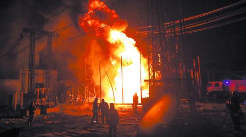 Firefighters work at a site of a thermal power plant damaged by a Russian missile strike in Kharkiv