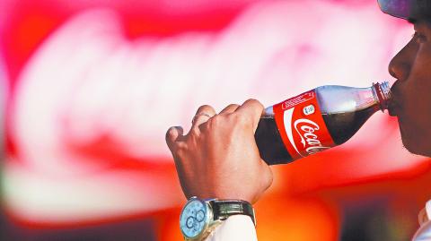 A man drinks a Coca-Cola at a store in Phnom Penh, Cambodia, December 5, 2016. REUTERS/Samrang Pring